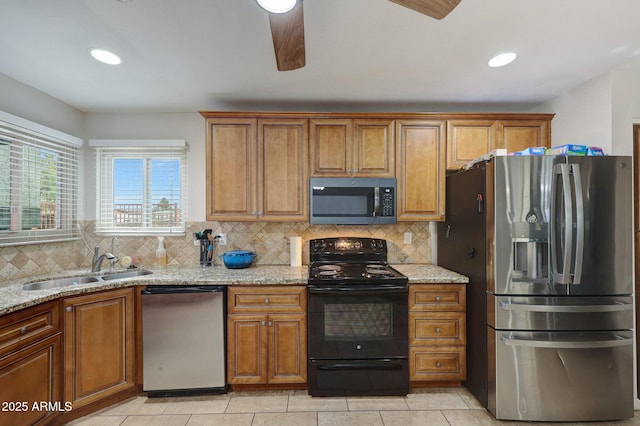 kitchen featuring appliances with stainless steel finishes, a sink, and brown cabinets