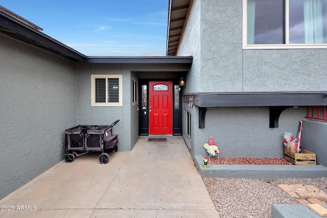 view of exterior entry featuring stucco siding