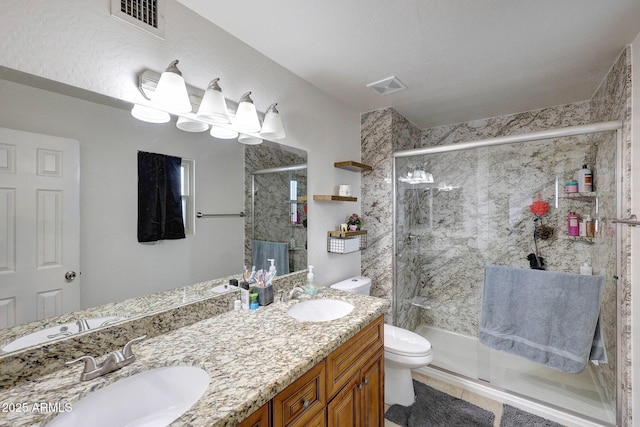 full bath featuring a stall shower, visible vents, a sink, and toilet