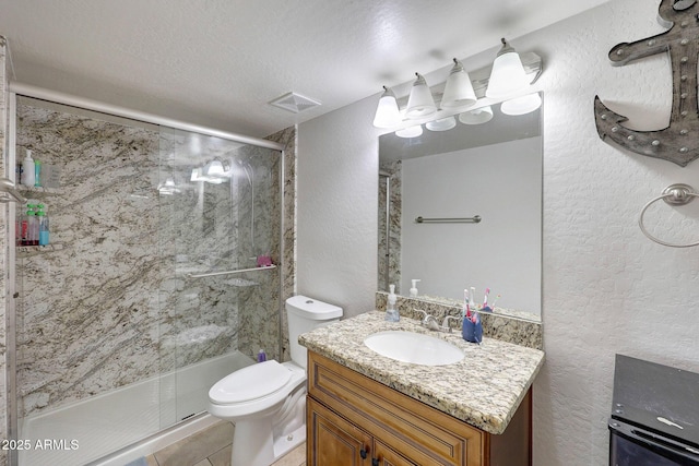 bathroom with a textured wall, a shower stall, and toilet