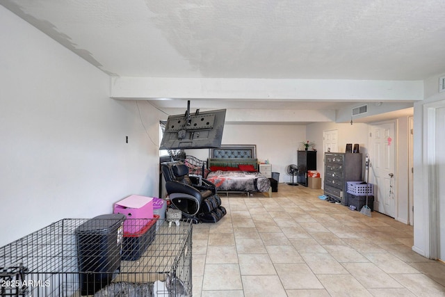 interior space with light tile patterned floors, visible vents, and a textured ceiling