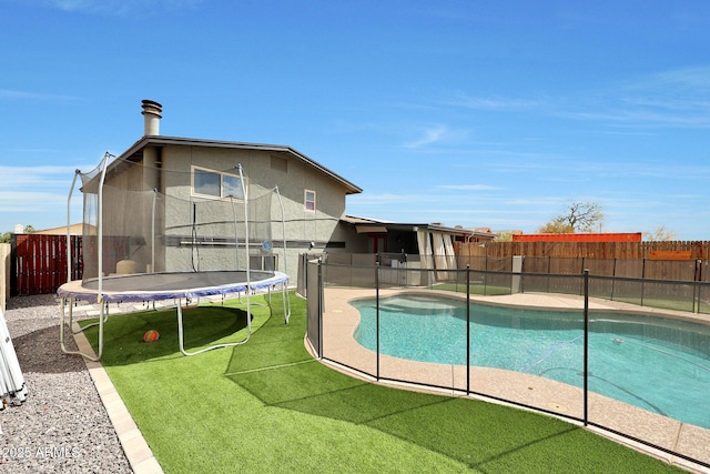 view of swimming pool featuring a trampoline, a fenced in pool, a patio, a lawn, and a fenced backyard