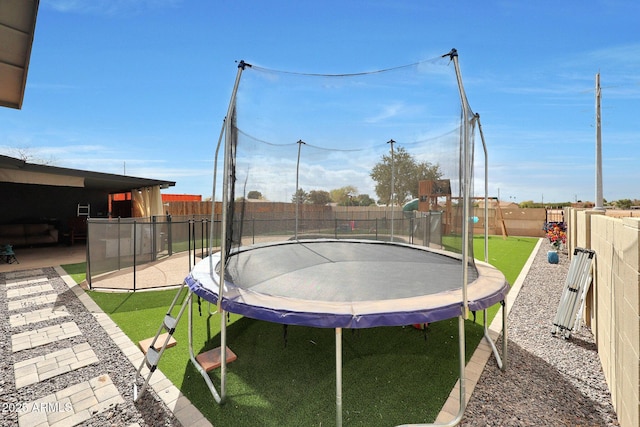 exterior space featuring a fenced backyard, a trampoline, and a patio