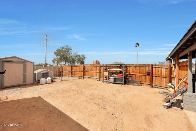 view of yard with an outbuilding, a storage unit, and a fenced backyard