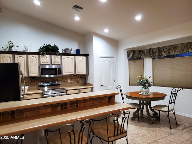 2101 S Meridian Rd Unit 437, Apache Junction, AZ 85120 - kitchen featuring stainless steel appliances, decorative backsplash, recessed lighting, lofted ceiling, and light tile patterned floors