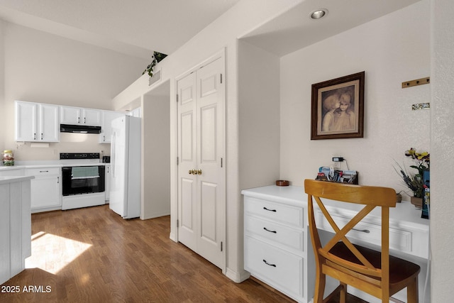 kitchen with under cabinet range hood, electric range, white cabinets, light countertops, and freestanding refrigerator