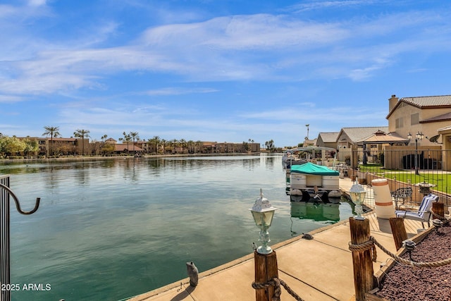 view of dock featuring a water view and fence