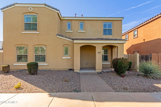 view of front of property with fence and stucco siding