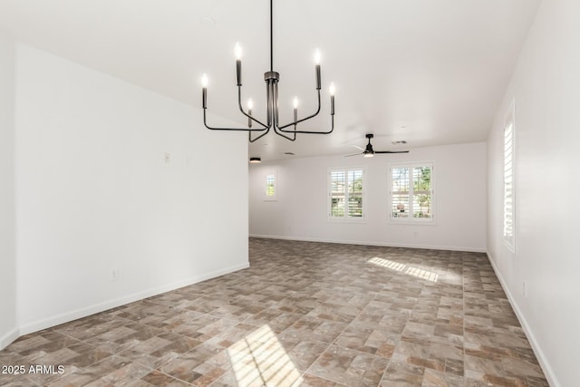 unfurnished room with baseboards and ceiling fan with notable chandelier