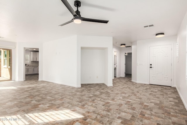 unfurnished living room with a ceiling fan, visible vents, and baseboards