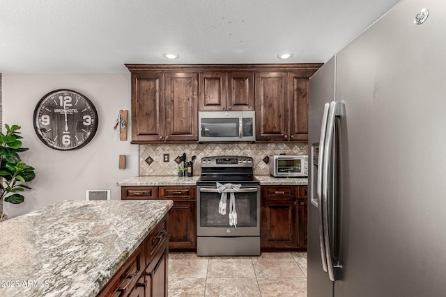 5110 E Mark Ln, Cave Creek, AZ 85331 - kitchen featuring stainless steel appliances, tasteful backsplash, light stone countertops, recessed lighting, and dark brown cabinets