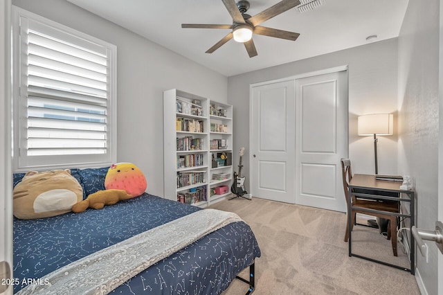 carpeted bedroom with a ceiling fan, visible vents, and a closet