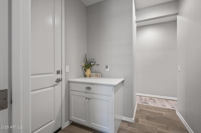 interior space featuring baseboards and wood finished floors