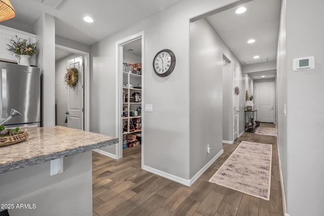 corridor featuring baseboards, dark wood-type flooring, visible vents, and recessed lighting