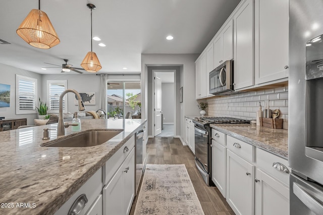 kitchen featuring tasteful backsplash, a healthy amount of sunlight, appliances with stainless steel finishes, and a sink