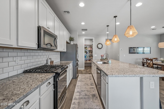 kitchen featuring wood finished floors, visible vents, stainless steel appliances, and a sink
