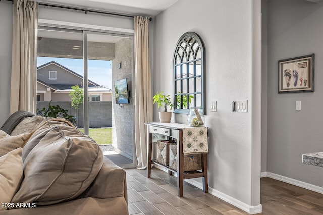 doorway featuring baseboards, wood finished floors, and plenty of natural light