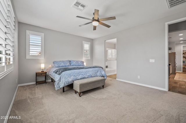 carpeted bedroom featuring freestanding refrigerator, visible vents, a ceiling fan, and baseboards
