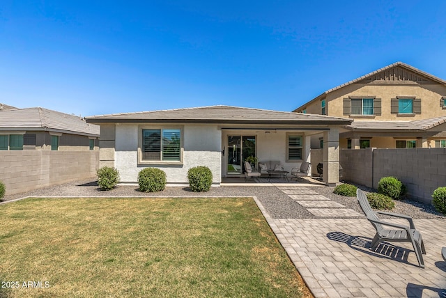 back of property with a lawn, a patio, a fenced backyard, and stucco siding