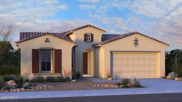 mediterranean / spanish house with a tile roof, driveway, an attached garage, and stucco siding