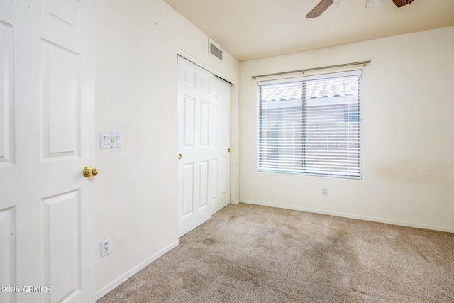 unfurnished bedroom featuring ceiling fan, light colored carpet, and a closet