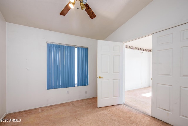 unfurnished bedroom with ceiling fan, light colored carpet, and lofted ceiling