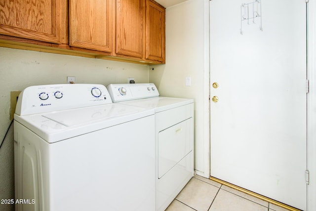 laundry room with cabinets, washing machine and clothes dryer, and light tile patterned floors