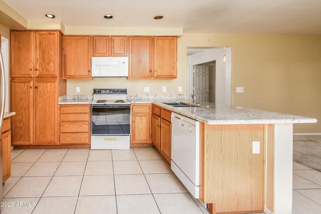 kitchen with light tile patterned flooring, sink, kitchen peninsula, white appliances, and light stone countertops