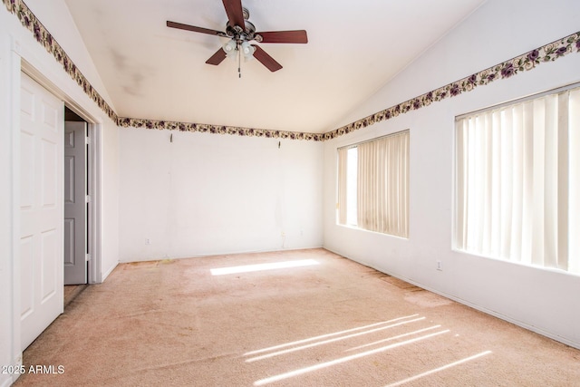 carpeted spare room featuring ceiling fan and lofted ceiling