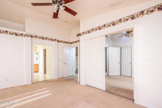 carpeted spare room featuring ceiling fan and lofted ceiling