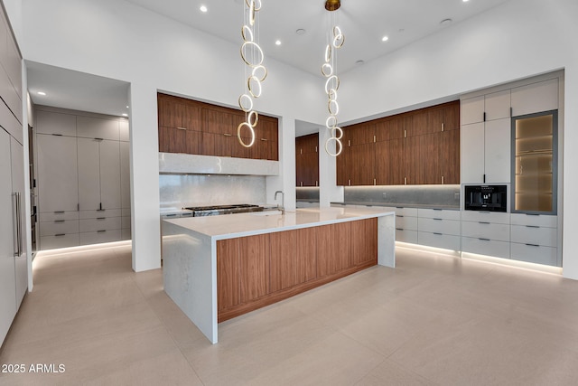 10354 E Celestial Dr, Scottsdale, AZ 85262 - kitchen featuring modern cabinets, a large island with sink, decorative backsplash, light countertops, and recessed lighting