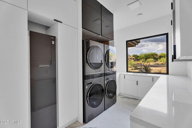 10354 E Celestial Dr, Scottsdale, AZ 85262 - laundry area featuring cabinet space, stacked washer / drying machine, and light marble finish flooring
