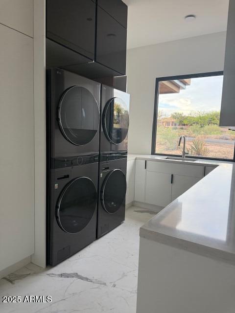 10354 E Celestial Dr, Scottsdale, AZ 85262 - laundry room featuring estacked washer and dryer, light marble finish flooring, and cabinet space