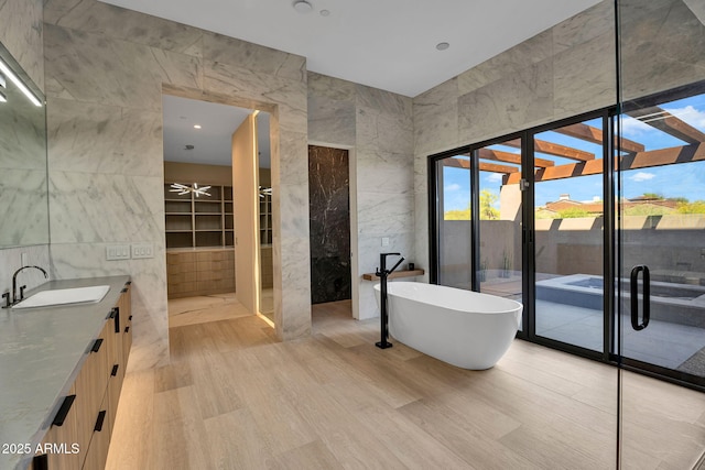 10354 E Celestial Dr, Scottsdale, AZ 85262 - full bath featuring tile walls, wood finished floors, a soaking tub, vanity, and a shower with door