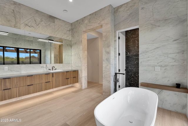 10354 E Celestial Dr, Scottsdale, AZ 85262 - bathroom with tile walls, a freestanding bath, vanity, and wood finished floors