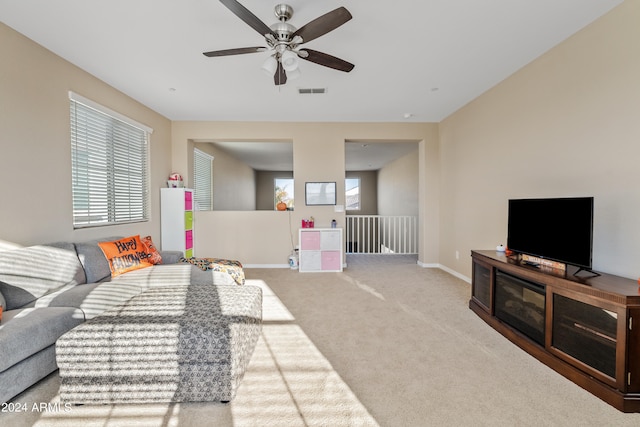 carpeted living room with ceiling fan