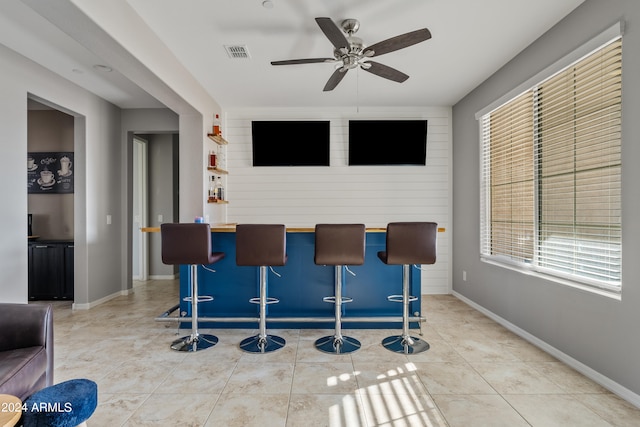 bar featuring ceiling fan and tile patterned flooring