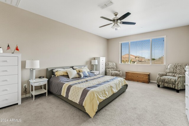 bedroom featuring ceiling fan, connected bathroom, and light carpet