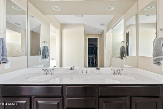 bathroom featuring tile patterned floors, a tile shower, and vanity