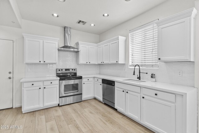 1225 N 36th St Unit 1015, Phoenix, AZ 85008 - kitchen featuring stainless steel appliances, wall chimney range hood, a sink, white cabinetry, and recessed lighting