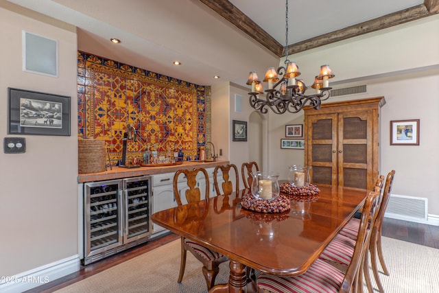 7302 E Rose Ln, Scottsdale, AZ 85250 - dining space featuring wine cooler, wood finished floors, baseboards, bar area, and a chandelier