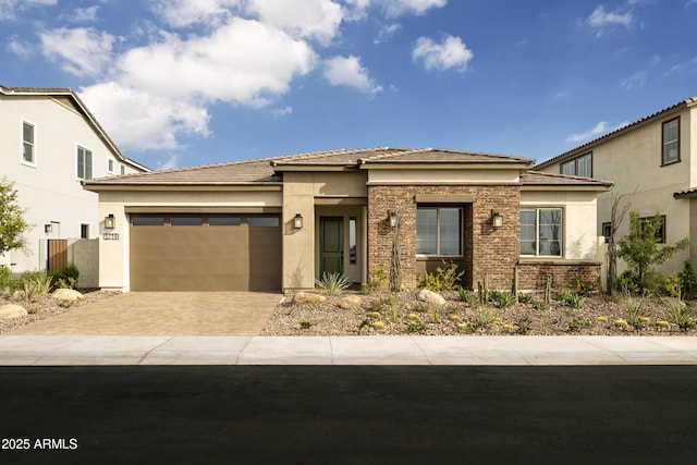 prairie-style home with driveway, an attached garage, a tile roof, and stucco siding