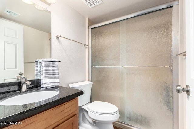 full bathroom featuring vanity, toilet, visible vents, and a stall shower