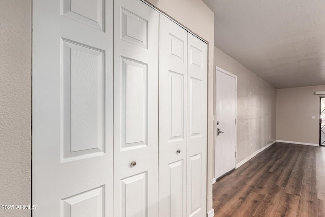 corridor with baseboards and dark wood-style floors