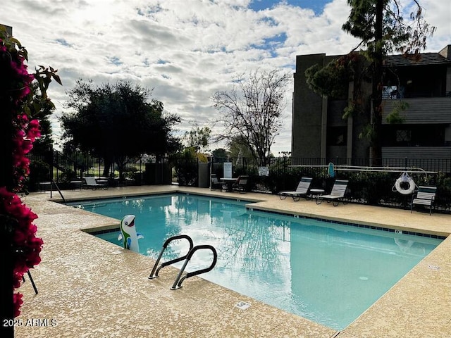 pool with a patio and fence