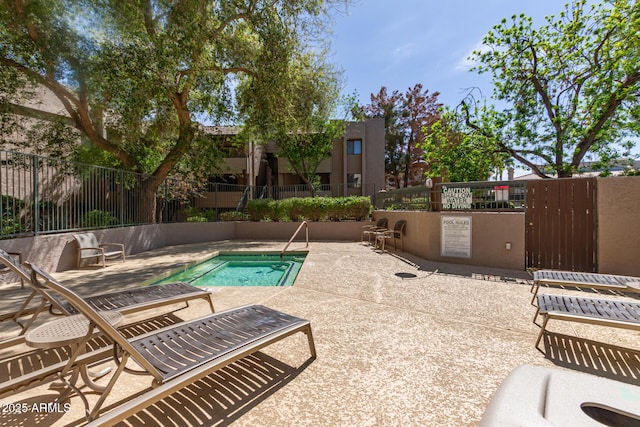 view of pool with a swimming pool, a patio, and fence