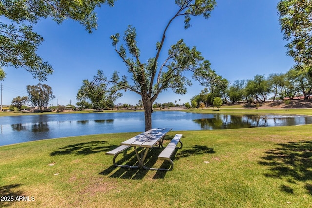 view of dock with a yard and a water view