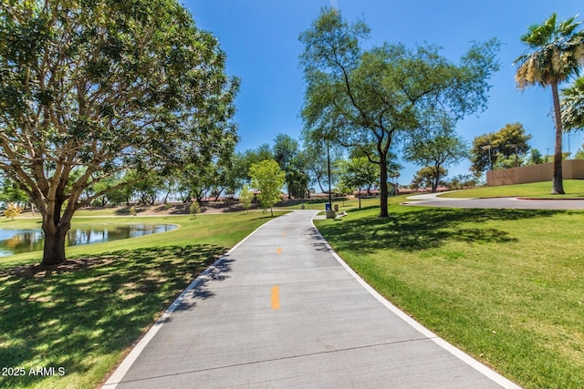 surrounding community featuring a lawn and a water view