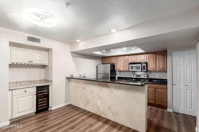 kitchen with visible vents, wine cooler, appliances with stainless steel finishes, and dark wood-style flooring