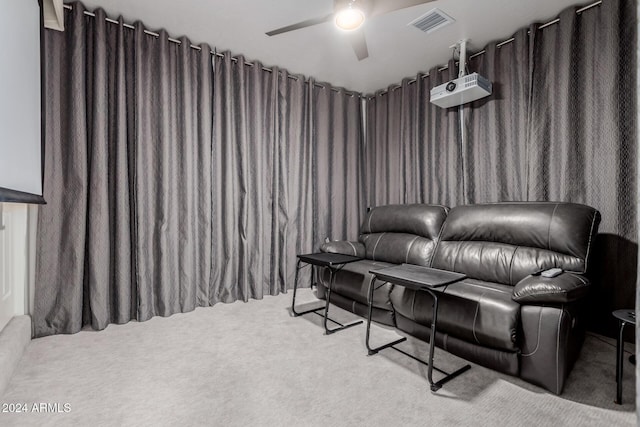 carpeted home theater room with ceiling fan